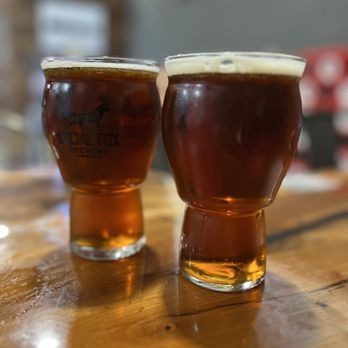 Social Fox Brewing & Distillery - two glasses of beer on a table - Brewpubs Near Me - Norcross, Georgia Social Fox Brewing & Distillery - two glasses of beer on a table - Brewpubs Near Me - Norcross, Georgia