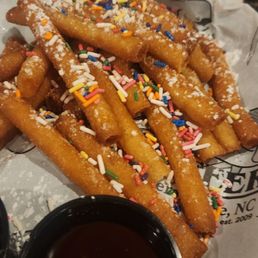 Funnel cake fries with whipped cream and hot chocolate dipping sauces Funnel cake fries with whipped cream and hot chocolate dipping sauces