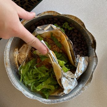 Costa Vida - a person picking up a taco from a bowl - Mexican Near Me - Apple Valley, Minnesota