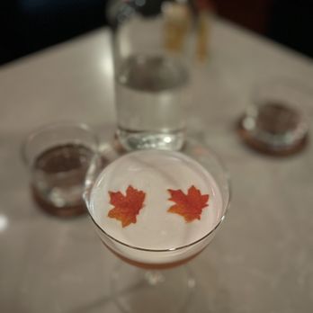 Wild Child - a glass filled with liquid and a maple leaf - Wine Bars Near Me - Shawnee, Kansas Wild Child - a glass filled with liquid and a maple leaf - Wine Bars Near Me - Shawnee, Kansas