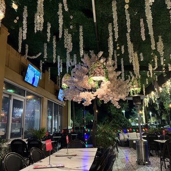 Kandela Tacos & Tequilas - a dining area with tables, chairs, and flowers hanging from the ceiling - Salad Near Me - Naples, Florida Kandela Tacos & Tequilas - a dining area with tables, chairs, and flowers hanging from the ceiling - Salad Near Me - Naples, Florida