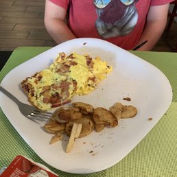 a person sitting at a table with a plate of food a person sitting at a table with a plate of food