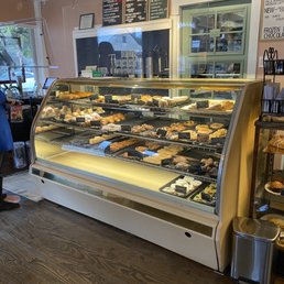 a woman standing in front of a display case of baked goods