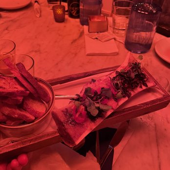 Due West - a person holding a plate of food - Cocktail Bars Near Me - New York, New York