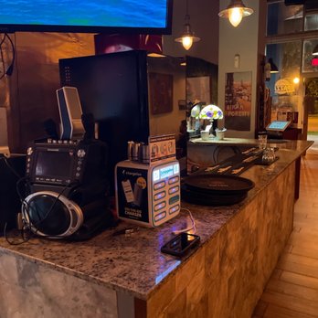 Pizza Pazza - a counter with a tv and a coffee maker - Pizza Near Me - Miami, Florida Pizza Pazza - a counter with a tv and a coffee maker - Pizza Near Me - Miami, Florida