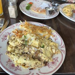Scrambled eggs with sun dried tomatoes, goat cheese and pine nuts and pancakes