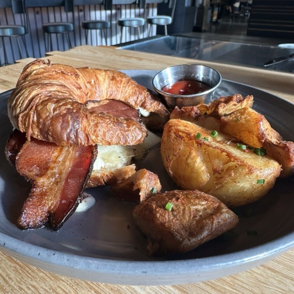 Salt Yard Cafe & Bar - Bacon, Egg, and Cheese on a Croissant with Seasoned Crispy Potatoes - New American Near Me - Portland, Maine Salt Yard Cafe & Bar - Bacon, Egg, and Cheese on a Croissant with Seasoned Crispy Potatoes - New American Near Me - Portland, Maine