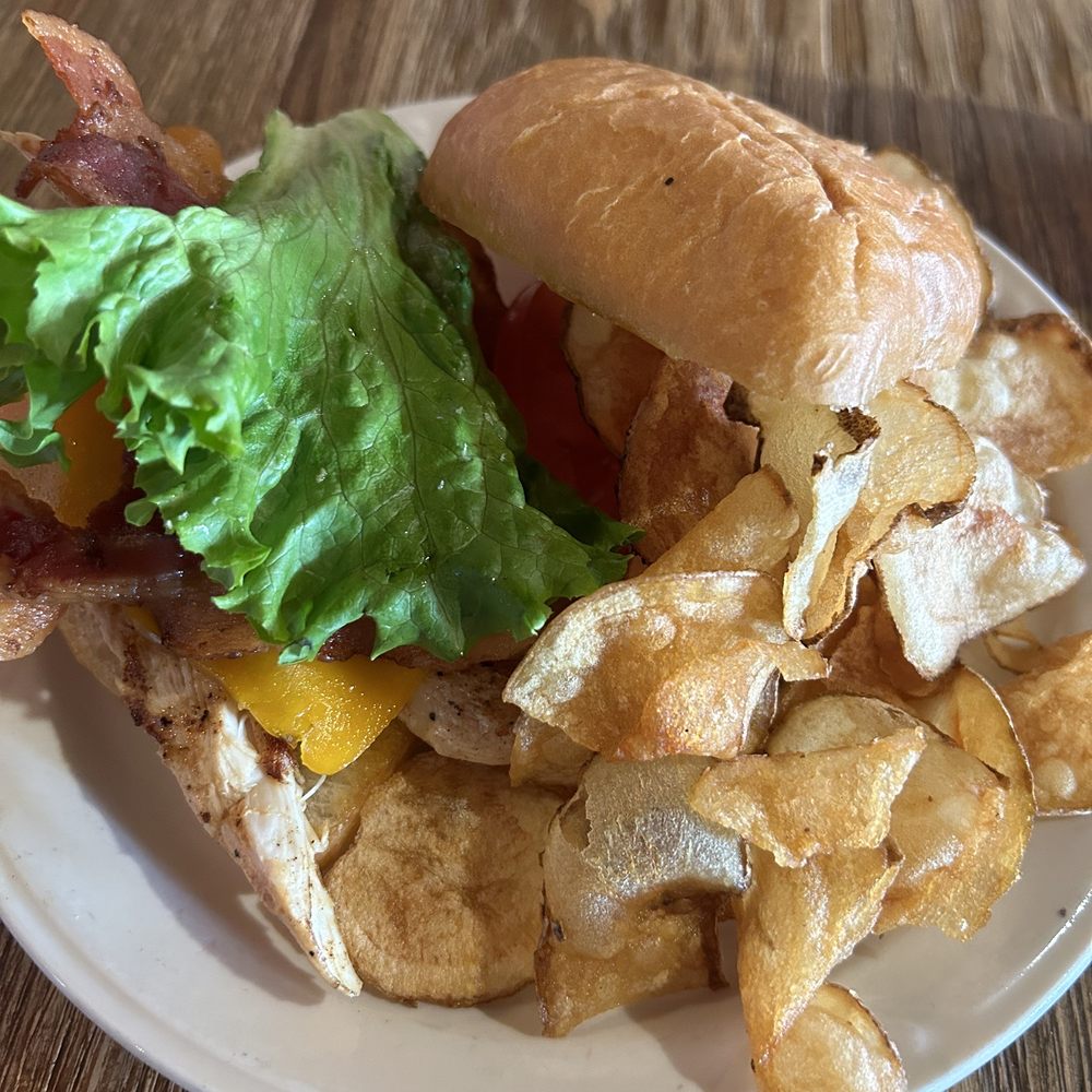 Grilled chicken club with lettuce, tomato with homemade chips Grilled chicken club with lettuce, tomato with homemade chips