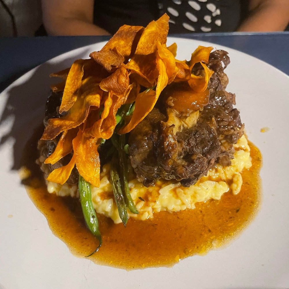SavannahBlue - Braises Oxtails served over Saffron Cheddar Risotto, topped with Crispy Root Vegetables - New American Near Me - Detroit, Michigan SavannahBlue - Braises Oxtails served over Saffron Cheddar Risotto, topped with Crispy Root Vegetables - New American Near Me - Detroit, Michigan