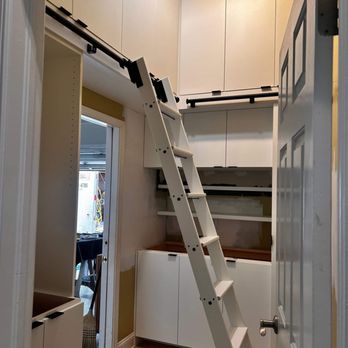Concept Woods - a kitchen with white cabinets and a ladder - General Contractors Near Me