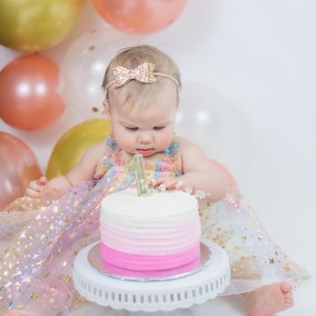 Sorella's Cake Studio - a baby girl sitting in front of a birthday cake - Custom Cakes Near Me - Livonia, Michigan