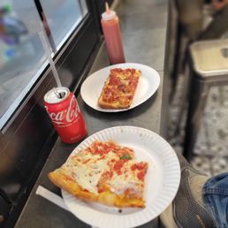 two slices of pizza on paper plates two slices of pizza on paper plates