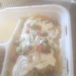 Wet supreme burrito with green sauce on top