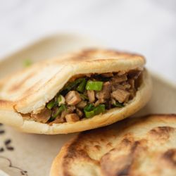 Happy Bao's - Rou Jia Mo is a traditional Chinese sandwich made from fresh dough and a savory meat filling.