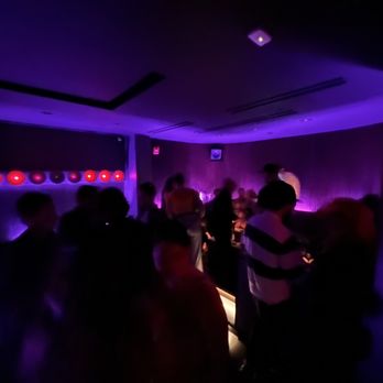 Outer Heaven - a group of people in a dimly lit room - Bars Near Me - New York, New York