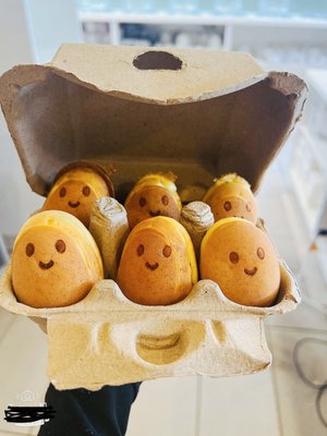Photo of Mr Waffle - Santa Ana, CA, US. a carton of eggs with faces drawn on them