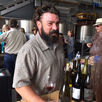 Urban Wine Row - a man holding a glass of wine - Wine Tasting Room Near Me - Marina, California Urban Wine Row - a man holding a glass of wine - Wine Tasting Room Near Me - Marina, California