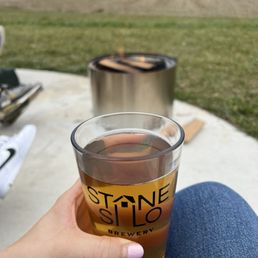 a person holding a glass of beer