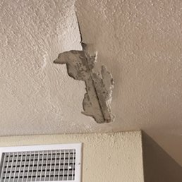 Hole in ceiling with peeling plaster