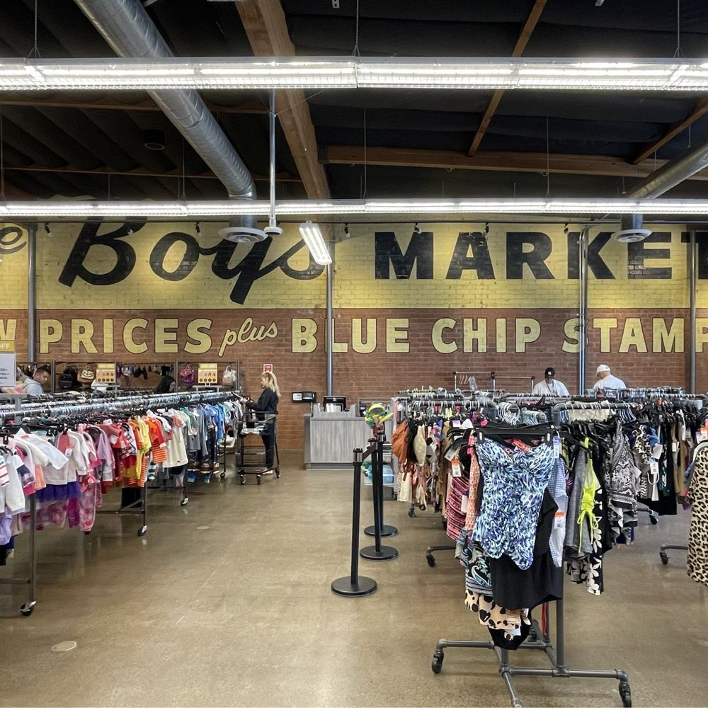 Immaculate clothing racks with painted signage on brick wall. Immaculate clothing racks with painted signage on brick wall.