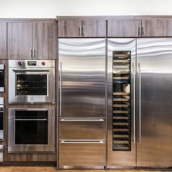 Bray & Scarff - Kitchen Appliance showroom with built-in stainless steel wall ovens, refrigerators, microwaves, and wine coolers