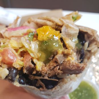 Quesada Burritos & Tacos - a hand holding a burrito - Mexican Near Me - New Westminster, British Columbia