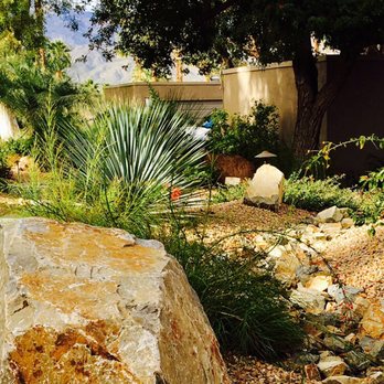 Professional Landscape Services - a large rock in a garden - Landscaping Near Me