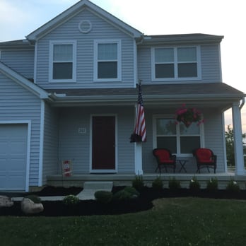 TNT Landscaping - the front of a house with a car parked in front of it - Landscaping Near Me