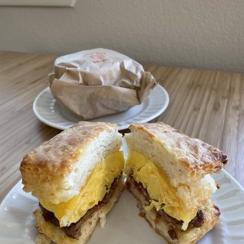 Little Ola's Biscuits - Sausage egg and cheese biscuit sandwich cut in half. Yum! Best biscuit and best egg and sausage. - Salad Near Me - Austin, Texas