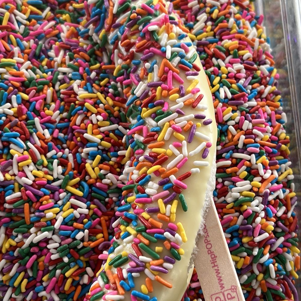 HipPOPs - Customized Frozen Banana white chocolate and sprinkles - Ice Cream & Frozen Yogurt Near Me - Sheridan, Colorado HipPOPs - Customized Frozen Banana white chocolate and sprinkles - Ice Cream & Frozen Yogurt Near Me - Sheridan, Colorado