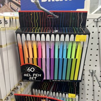Five Below - Gel pens - The image features a retail display of 60 gel pens in a variety of colors, arranged vertically in a black packaging with colorful line patterns. The display is located in a store aisle, with a yellow price tag indicating $5.00. The background includes a sign for 'Sketch & Draw' and store shelving. The pens are in a plastic case with a fold-up cover, and a pen is attached to the display with a clip. - Discount Store Near Me - American Fork, Utah