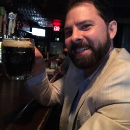 a man holding up a glass of beer
