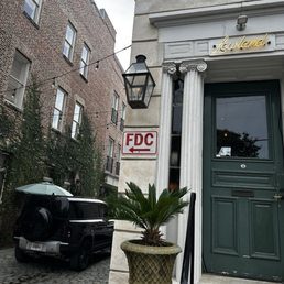 Outside of restaurant, small waiting area in the front and cobblestone streets on the side street.