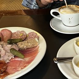 Curated meat charcuterie board, cappuccino and bread Curated meat charcuterie board, cappuccino and bread
