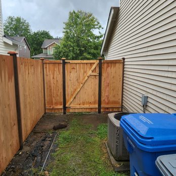 RK Fencing & Construction - a fence and a trash can - General Contractors Near Me