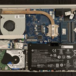 White Flag Computing - Typical laptop opened up, showing motherboard, CPU cooler, fan, hard drive, RAM (memory) and battery