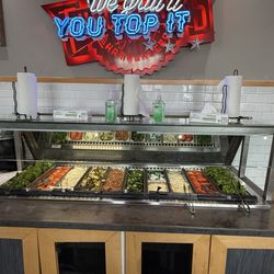 Fuddruckers - You add your own cold toppings at the bar.