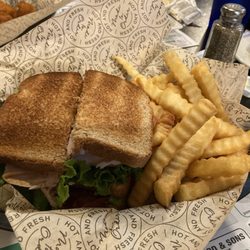 Turkey club sandwich with fries.