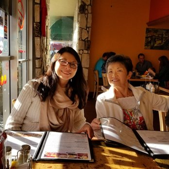 Momo's Cafe - Eating area about 15 x 15.  Tables on a pole, wooden kitchen chairs, glass storefront. - American Near Me - Vallejo, California