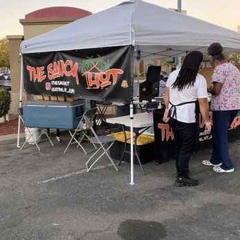 The Saucy Hut - a group of people standing under a tent - Food Trucks Near Me - Oakland, California The Saucy Hut - a group of people standing under a tent - Food Trucks Near Me - Oakland, California