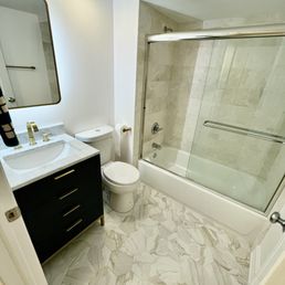One of the bathrooms after the full gut. Walls, tile, hardware, toilet, tub all replaced.