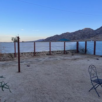 Marquez Fencing - Extended corrugated panels to rock wall to enlargen backyard space - Fences & Gates Near Me