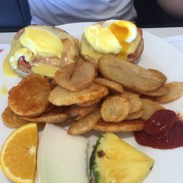 Smoked salmon eggs Benedict with potatoes and fruit
