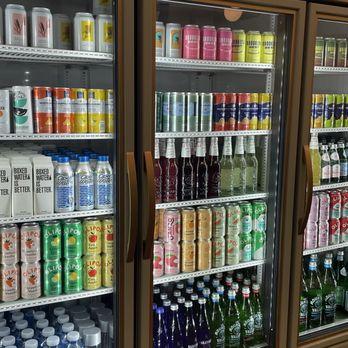 Victorian Cafe - Three glass-door refrigerators filled with canned and bottled drinks, including soda, water, and juice, at Victorian Café in Brooklyn. - Cafes Near Me - Brooklyn, New York