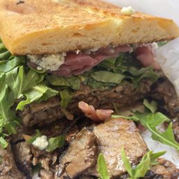 WHISKEY CRACK (grilled burgundy pepper trip tip, whiskey-peppercorn sauce, blue cheese, pickled onions, and arugula) on a ciabatta roll WHISKEY CRACK (grilled burgundy pepper trip tip, whiskey-peppercorn sauce, blue cheese, pickled onions, and arugula) on a ciabatta roll