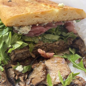 Seaside Market - WHISKEY CRACK (grilled burgundy pepper trip tip, whiskey-peppercorn sauce, blue cheese, pickled onions, and arugula) on a ciabatta roll - Grocery Near Me - Cardiff, California Seaside Market - WHISKEY CRACK (grilled burgundy pepper trip tip, whiskey-peppercorn sauce, blue cheese, pickled onions, and arugula) on a ciabatta roll - Grocery Near Me - Cardiff, California