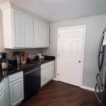 Foolproof Tile Installation - a kitchen with white cabinets and black countertops - General Contractors Near Me - Denver, Colorado