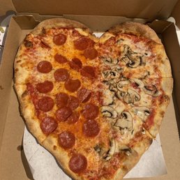 Heart shaped pizza for Valentine's Day with half pepperoni and half mushrooms Heart shaped pizza for Valentine's Day with half pepperoni and half mushrooms