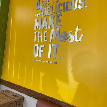 Pollo Campero - a man standing in front of a sign that says life is delicious make the most of it - Latin American Near Me - Chicago, Illinois Pollo Campero - a man standing in front of a sign that says life is delicious make the most of it - Latin American Near Me - Chicago, Illinois
