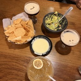 Queso and chips with guacamole and drinks Queso and chips with guacamole and drinks